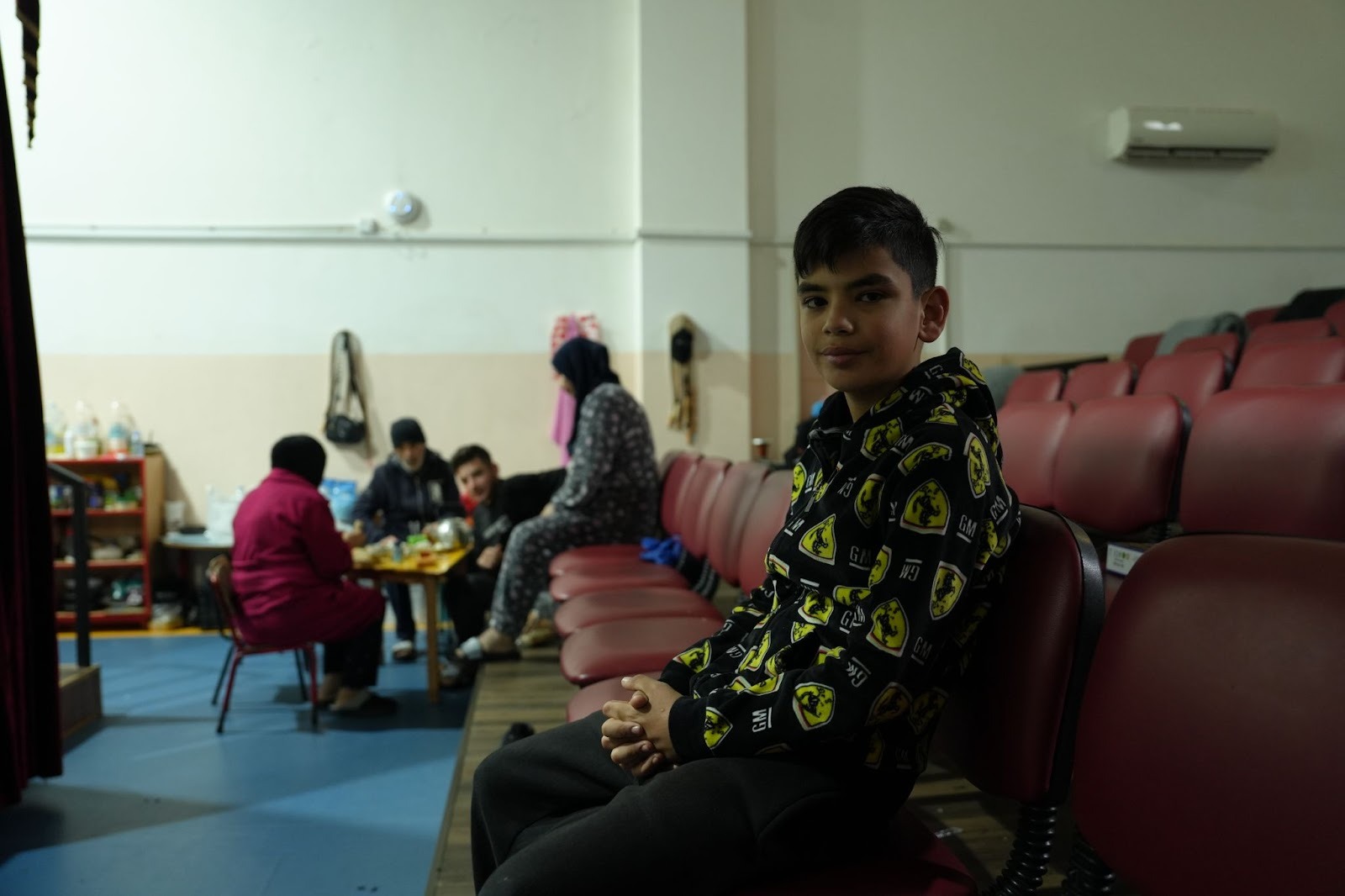 Souhail*’s family has lunch in an empty class inside the school they are sheltering in. Photo by Adeeb Farhat.
